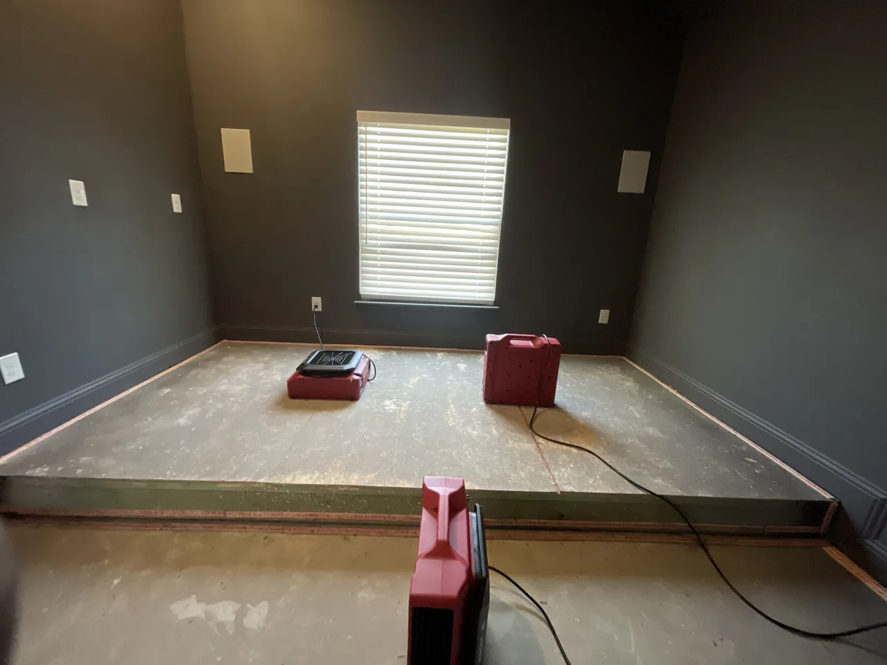 Air-moving equipment positioned over exposed residential floor surfaces